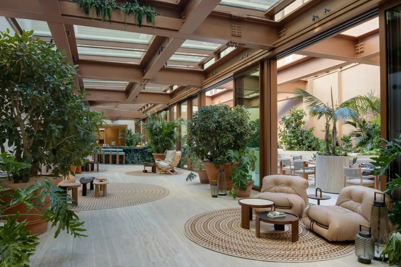 Vue de l'entrée couverte, arborée et équipée de canapés du restaurant café bar "Bivium" du Six Senses