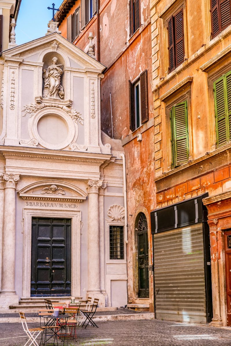 The small and lovely square of Largo dei Librari and the little Baroque style church of Santa Barbara dei Librai (Saint Barbara), located near Campo de Fiori, in the historic heart of the Eternal City. Perhaps built since Roman times by a noblewoman of Christian faith above the ruins of the Theater of Pompey, this delightful little church was officially founded in 1306. The statue on the facade, above, depicting Saint Barbara, is the work of the Baroque artist Ambrogio Parisi. The Campo de Fiori area is much loved and visited by tourists and residents for the presence of ancient churches and noble palaces and for the countless artistic and cultural treasures in Renaissance and Baroque style. Around Campo de Fiori, in the ancient Parione and Regola districts, it is possible to explore dozens of characteristic alleys, where you can discover the essence and soul of Roman life. In 1980 the historic center of Rome was declared a World Heritage Site by Unesco. Super wide angle image in high definition format.