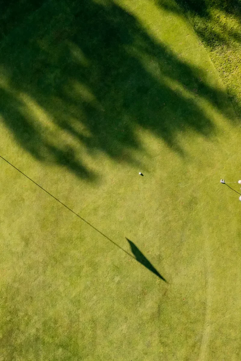 Drone perspective view of a golfer lining up a putt on the green. Shot on location on a golf course on the island of Moen in Denmark. Horizontal format with some copy space.