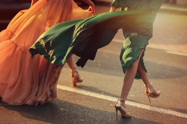Women wearing elegant dresses, street style detail.