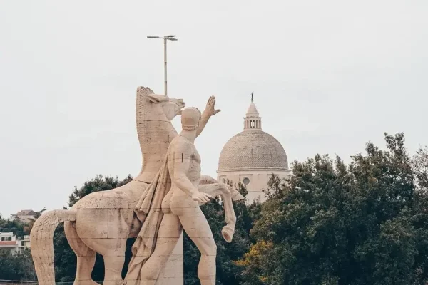 Statue au pied du Colisée carré représentant un homme saluant une foule avec son cheval qui cabre